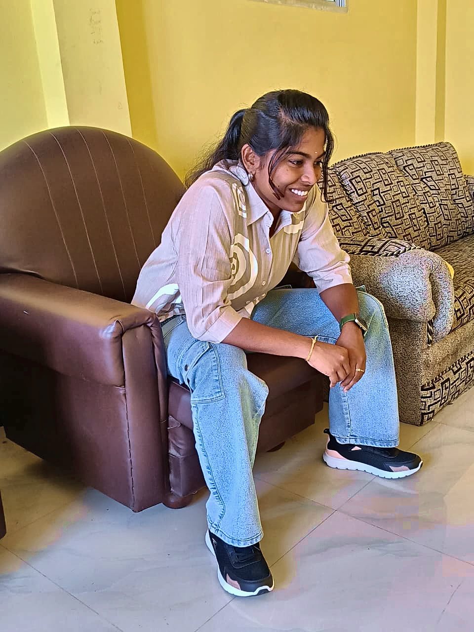 Kaviya laughing on the sofa